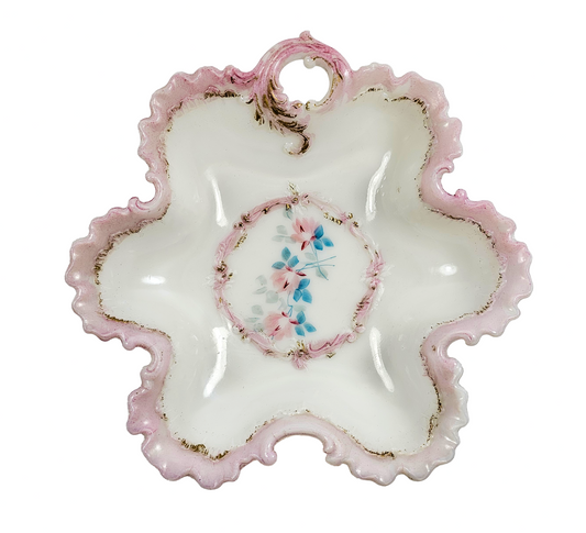 Decorative ceramic plate with pink rim and floral center on a white background