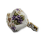 Decorative ceramic flower holder with gold accents and floral patterns on a white background