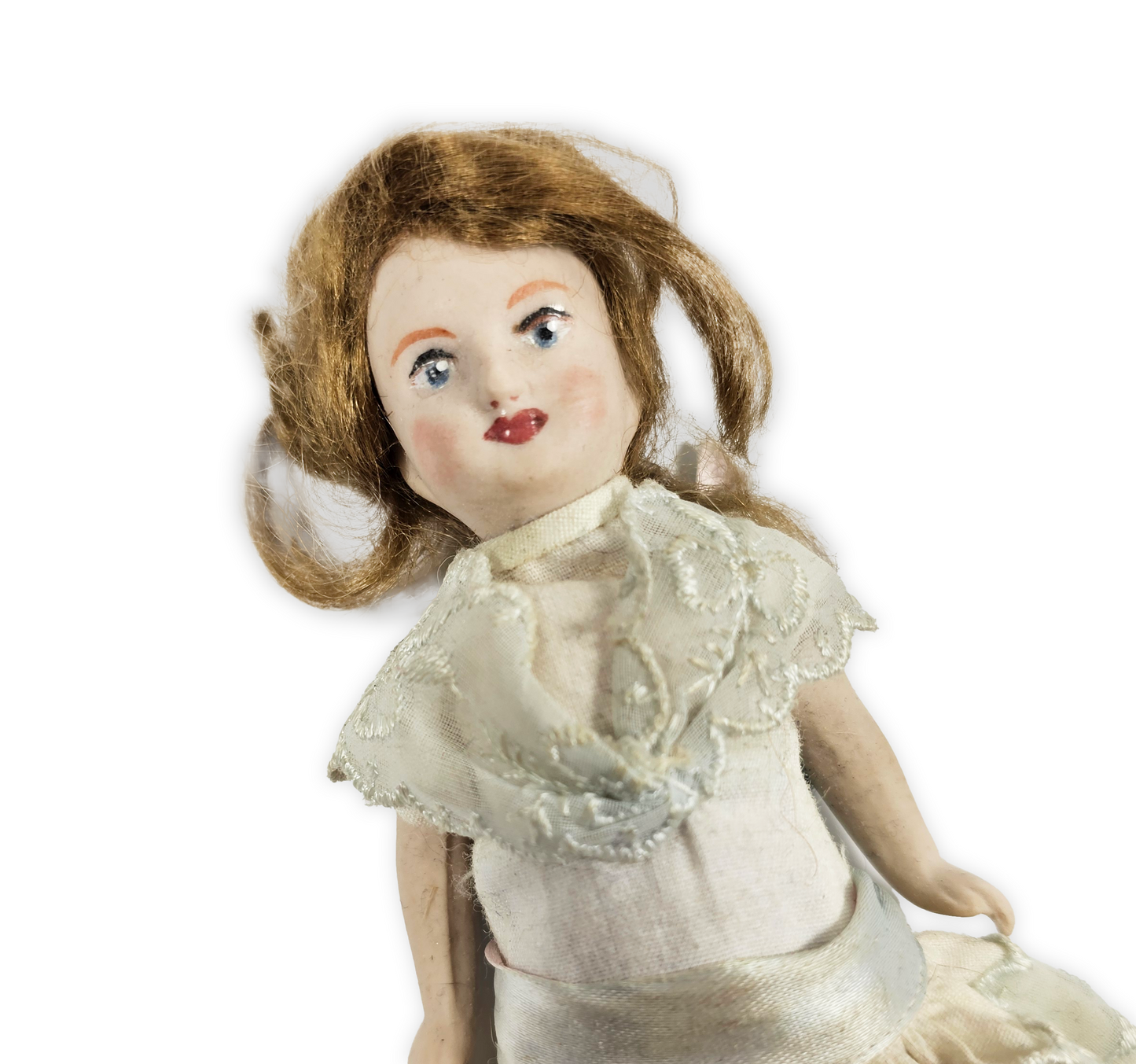 antique doll with brown hair and a white dress on a white background