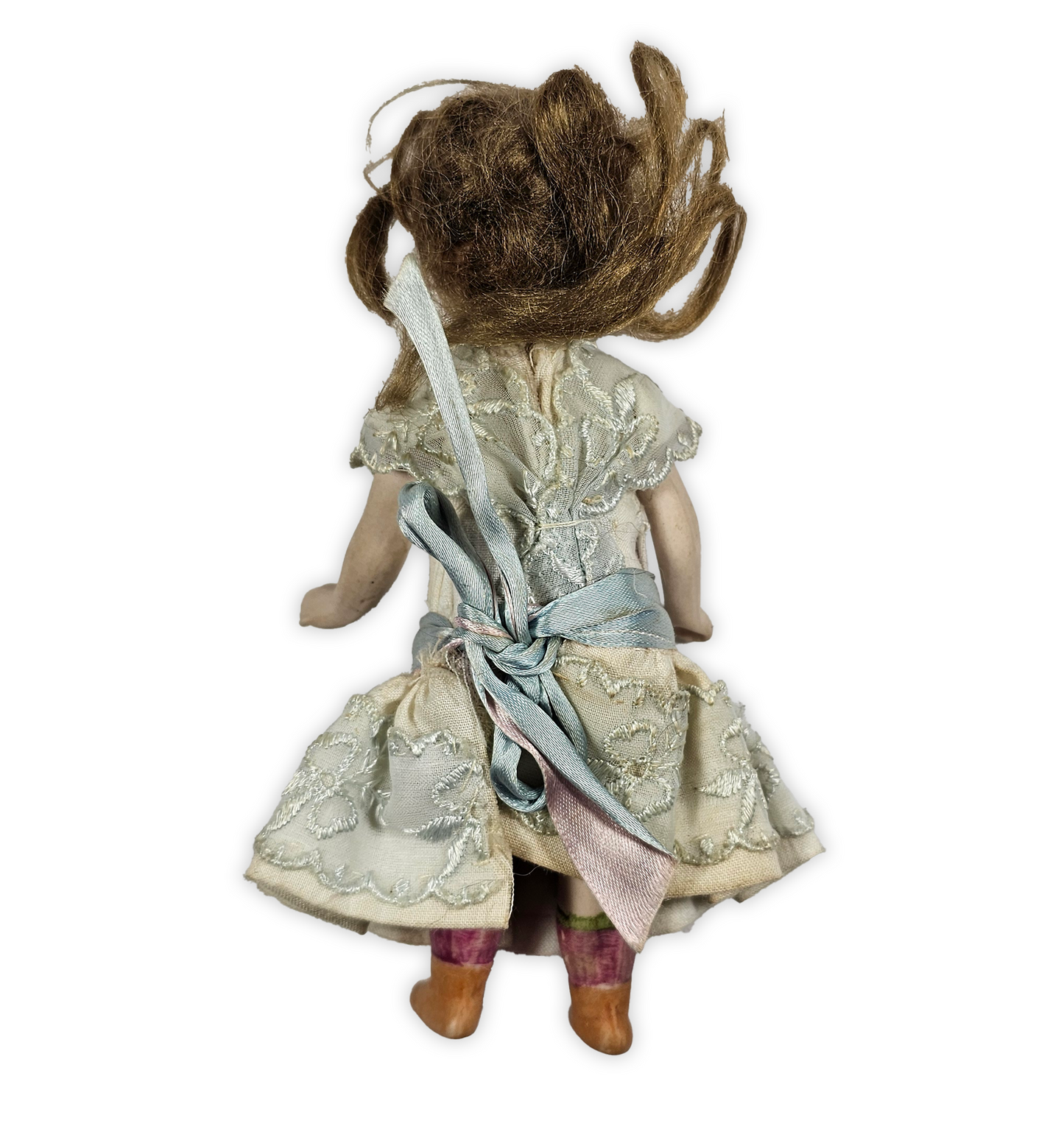 antique doll with brown hair and a lace dress on a white background
