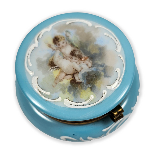 Round blue decorative item with an angel design on a white background