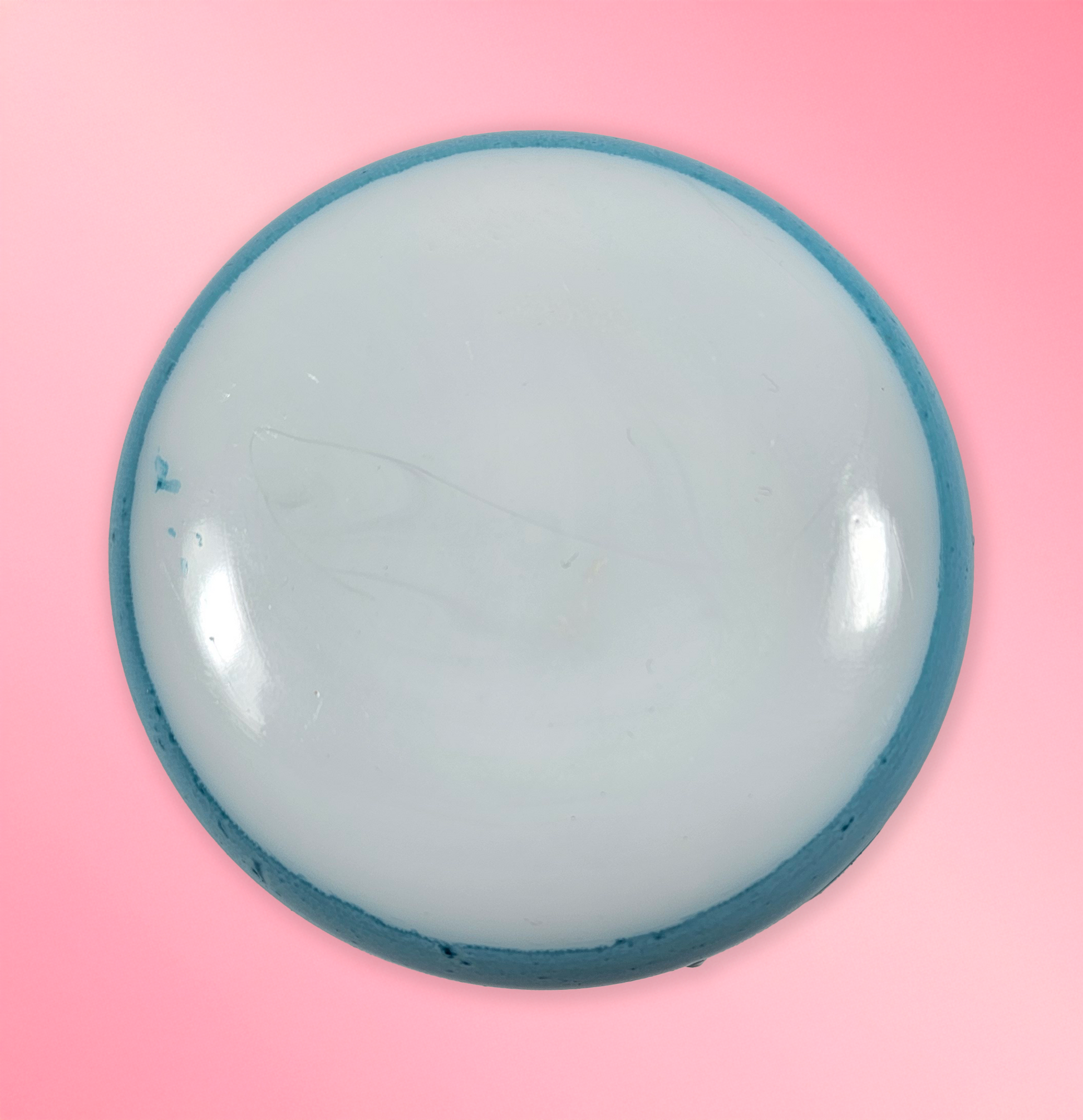 Round blue object on a pink background