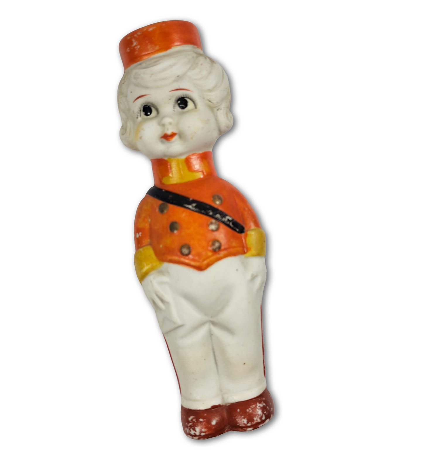 Vintage ceramic figurine of a boy in an orange outfit with a white background