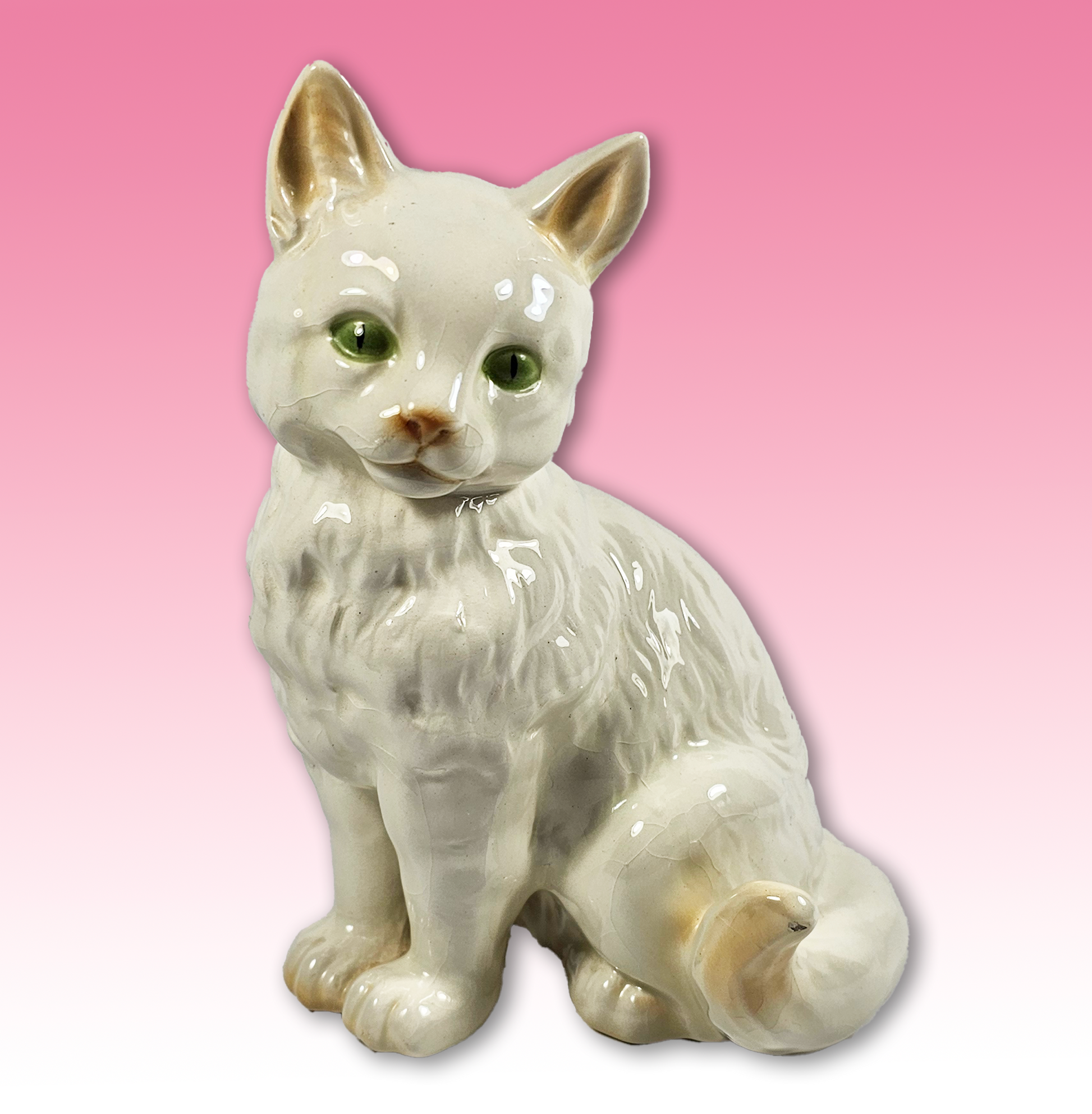 White ceramic cat figurine on a pink background