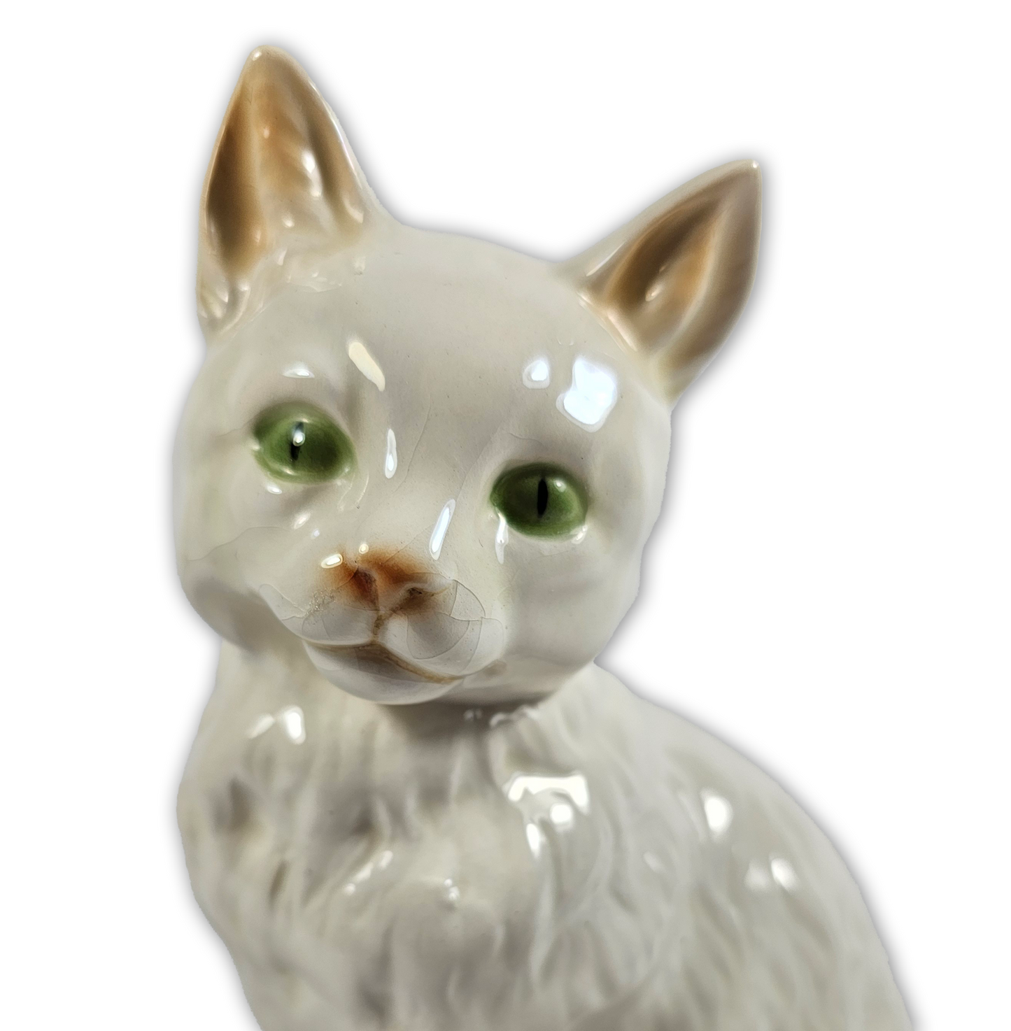 Ceramic cat figurine with green eyes on a white background