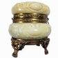 Decorative white container with gold accents on a white background
