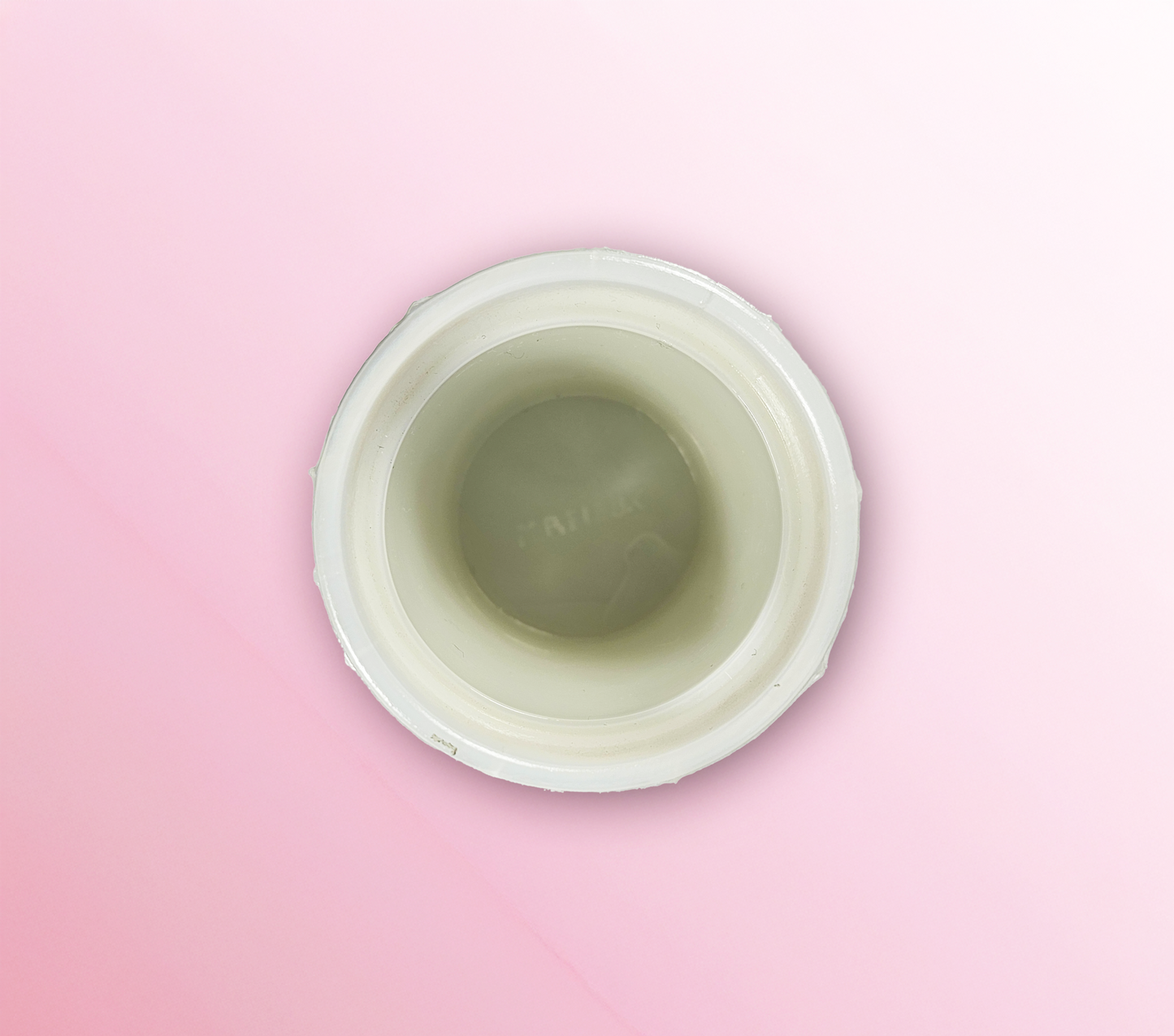 Top view of a white container with a pink background