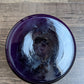 Purple glass roumd box on a wooden surface