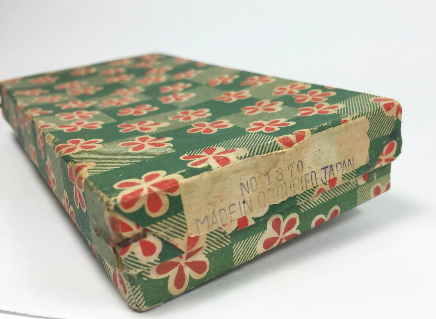 Vintage box with floral pattern and 'Made in Occupied Japan' label on a white background