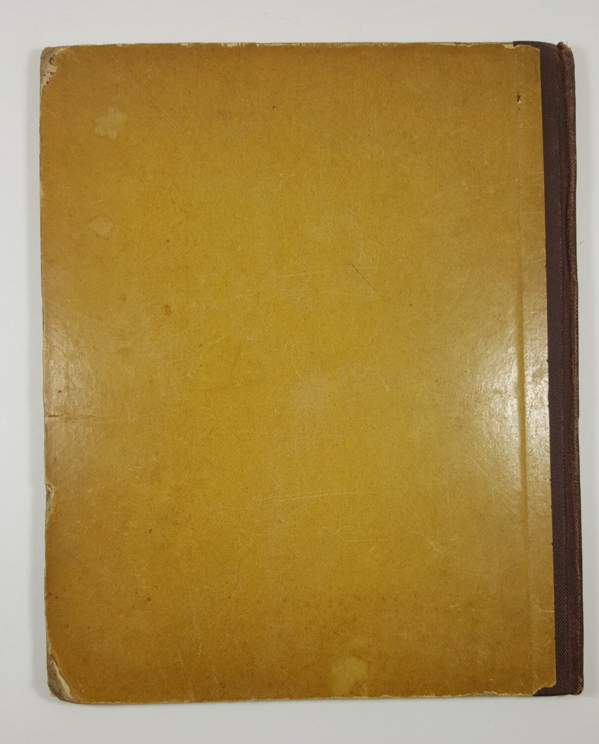 Vintage yellow book with brown spine on a white background