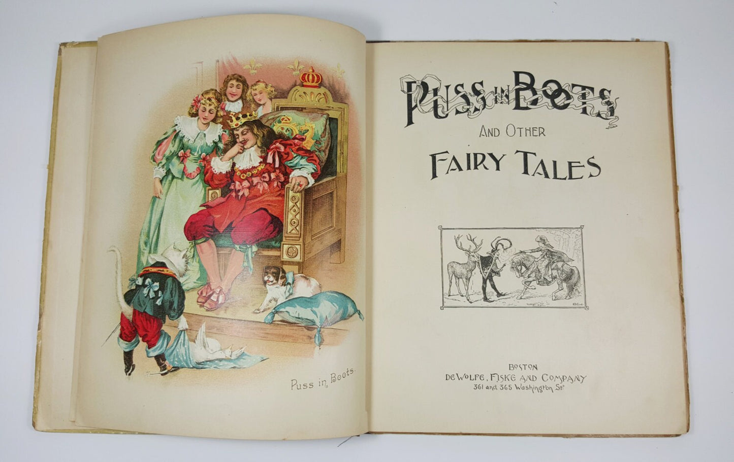 Open book titled 'Puss in Boots and Other Fairy Tales' with illustrations on a white background